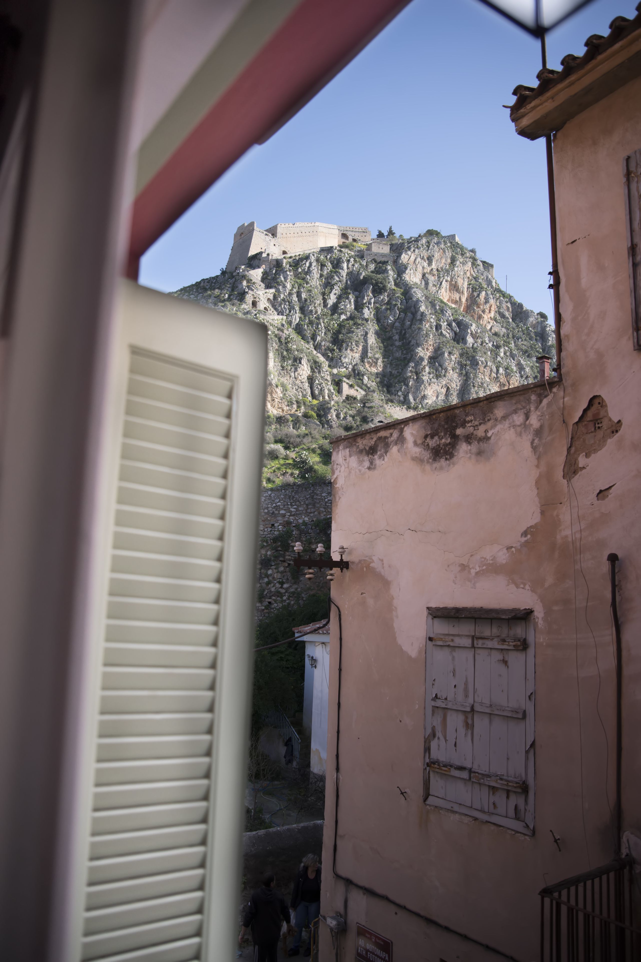 A view of a mountain fortress from a building with a window and a door.