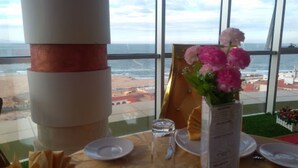 A table set for dining with a view of the beach and ocean through large windows. - Al Mansour Palace (Mazagran)