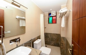 Une salle de bain moderne équipée d’un lavabo, de toilettes et d’une douche.