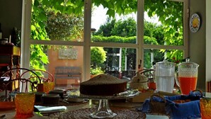 A room with large windows, a cake on a stand, and various glass containers.