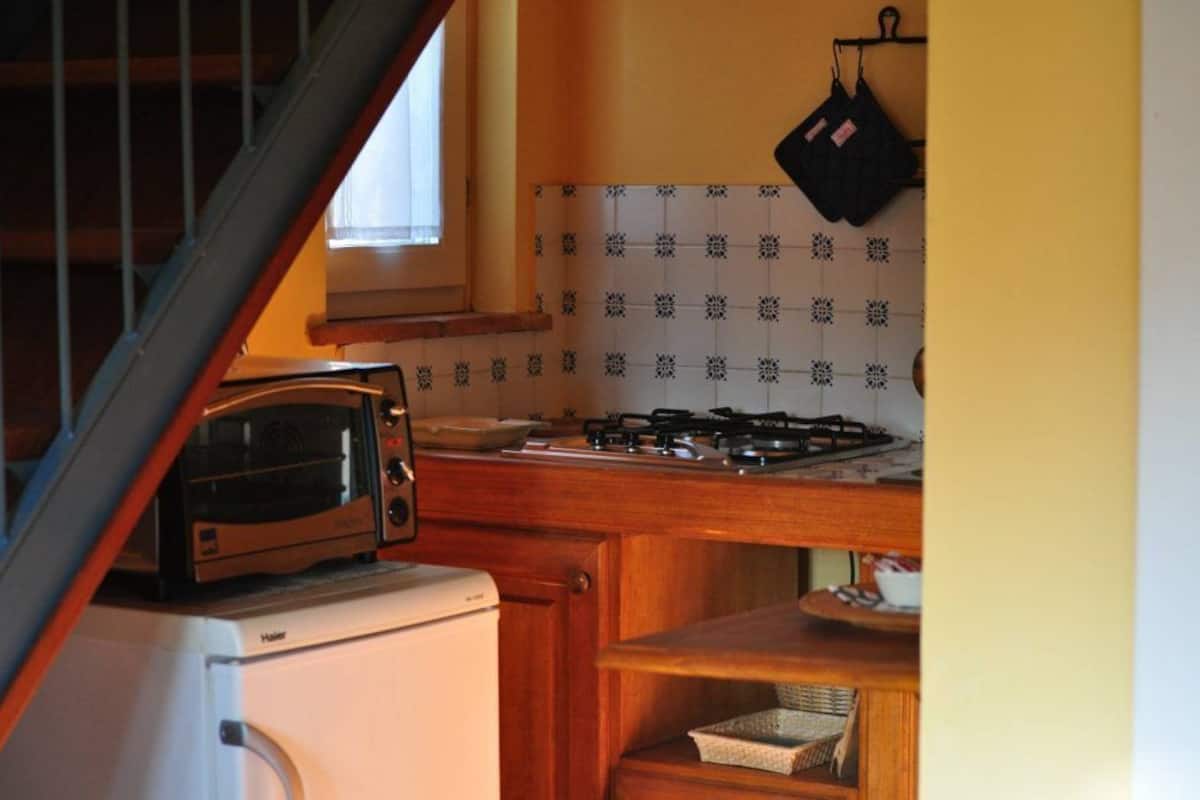 A kitchen with a toaster, stove, and hanging oven mitts.