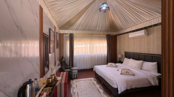 A hotel room with a bed, a small table with a tray of items, a chair, and a decorative ceiling.