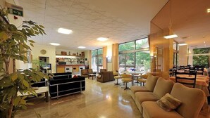 A spacious lobby with a seating area, a reception desk, and large windows offering a view of the outdoors. - Hotel Miramare et de la Ville (Miramare di Rimini)