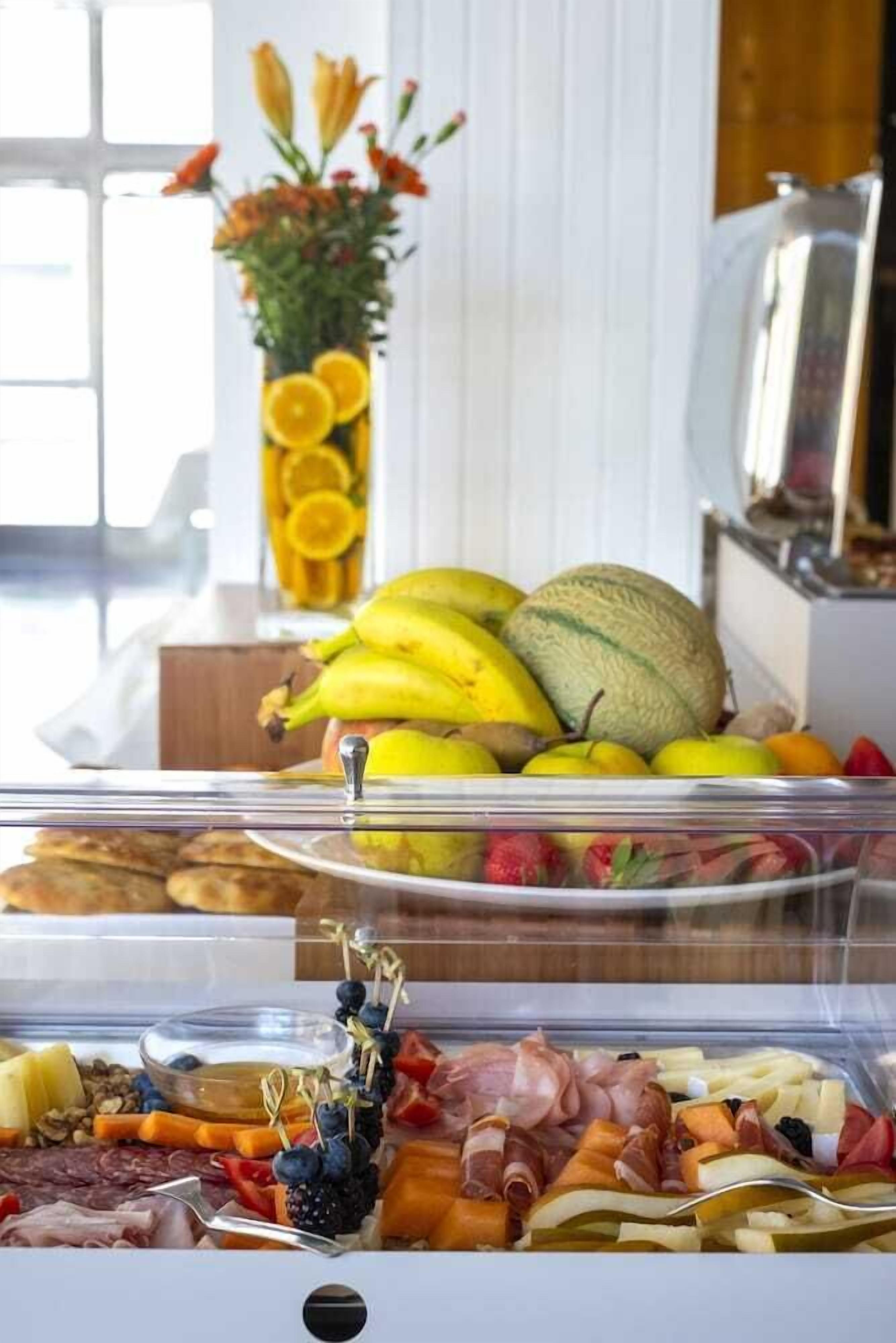 A buffet with various fruits, cheeses, and meats.