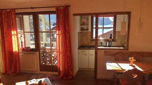 Una cucina accogliente con vista, armadietti in legno e un'area pranzo con tavolo e sedie.