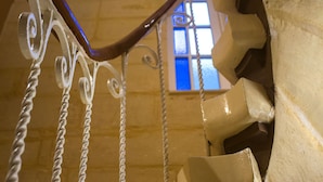 A spiral staircase with a wooden finish and white balusters. - Casa Azzopardi Suites (Rabat)