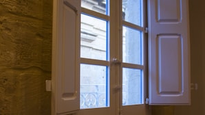 A double door with glass panels, set in a room with a stone wall and patterned floor. - Casa Azzopardi Suites (Rabat)