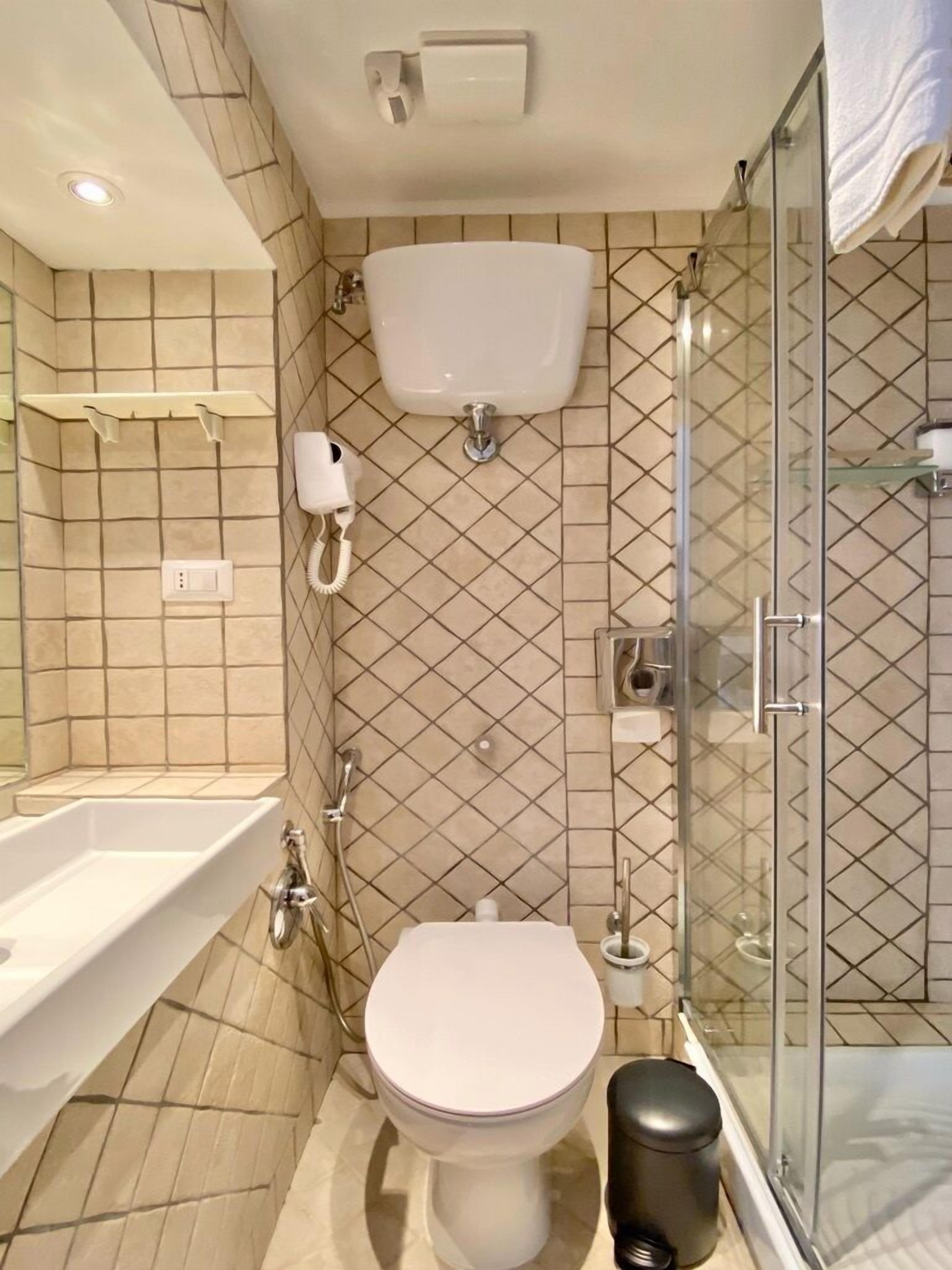 A modern bathroom with a toilet, sink, and shower.