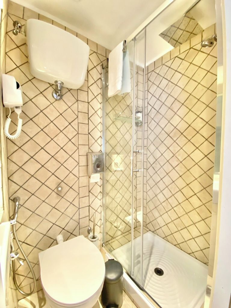 A bathroom with a toilet, bidet, and shower enclosure.