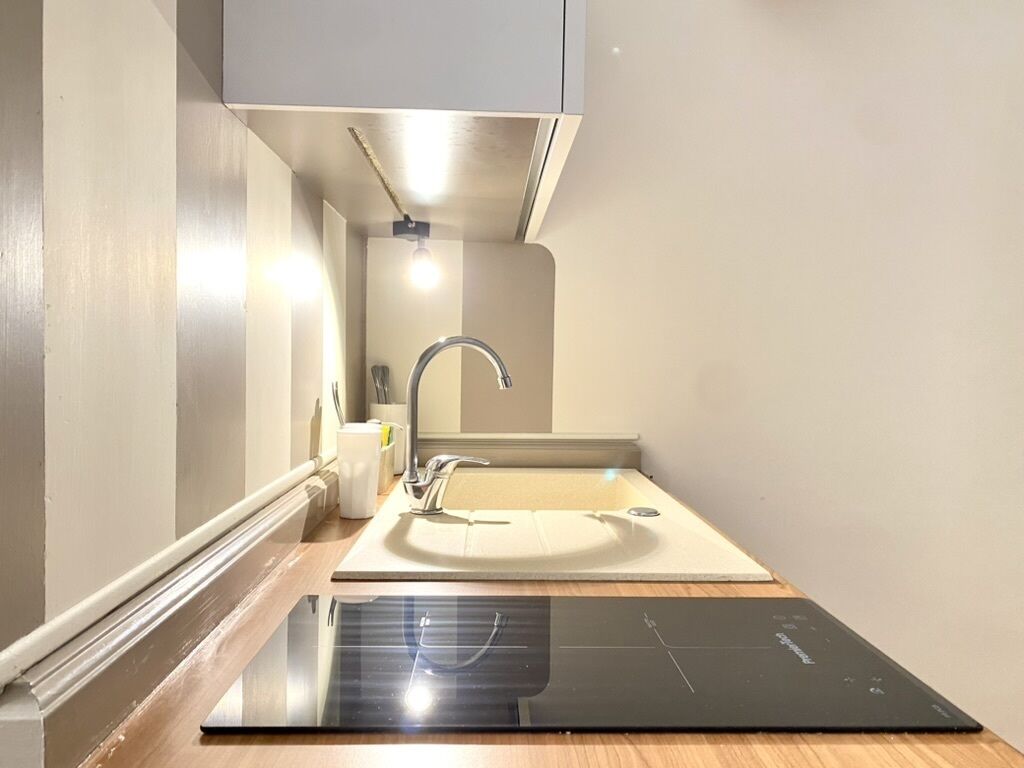 A modern kitchen with a built-in stove, a sink, and a cabinet above the sink.