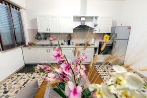 A kitchen with white cabinets, a gas stove, and a refrigerator. - B&B Casa Anna Maria (Porto Sant'Elpidio)