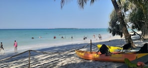 Am Strand, weißer Sandstrand, Sonnenschirme, Strandtücher