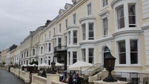 A row of white buildings with bay windows and a balcony railing. - Chatsworth House Hotel (Llandudno)