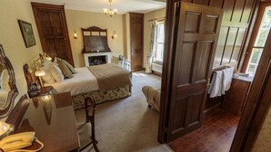 Une chambre d’hôtel avec un lit, une table de chevet, une lampe et un miroir.
