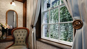 Une pièce avec une grande fenêtre, un miroir et une chaise.
