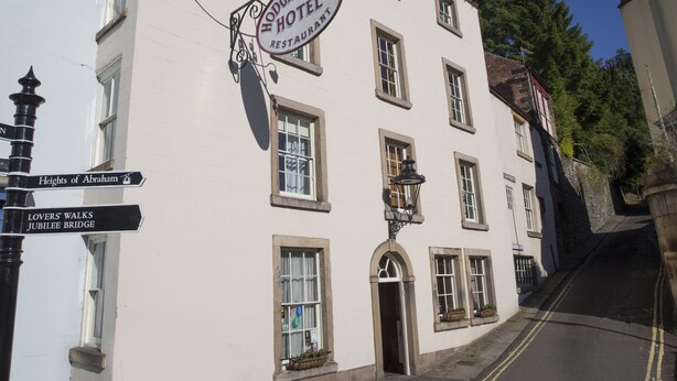 Un bâtiment à deux étages, avec une enseigne indiquant «Hodgkinson's Hotel Restaurant» au niveau supérieur. Il y a des fenêtres aux deux étages, et un lampadaire est visible au rez-de-chaussée.