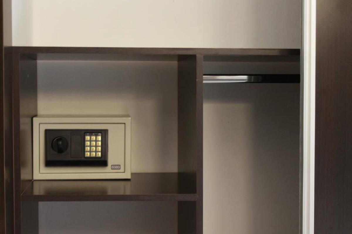 Una caja fuerte segura con cerradura numérica, ubicada en un compartimento de un mueble de madera.