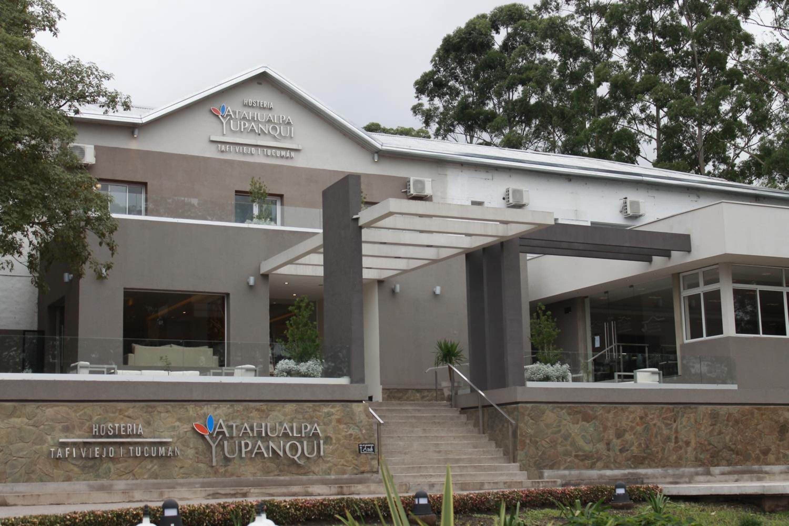 A modern building with a sign reading "Hosteria Atahualpa Upanqui" and "TAFI VIEJO TUCUMAN".