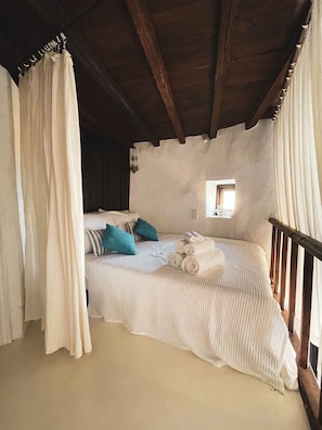 Une chambre confortable avec un lit, des oreillers et une fenêtre.