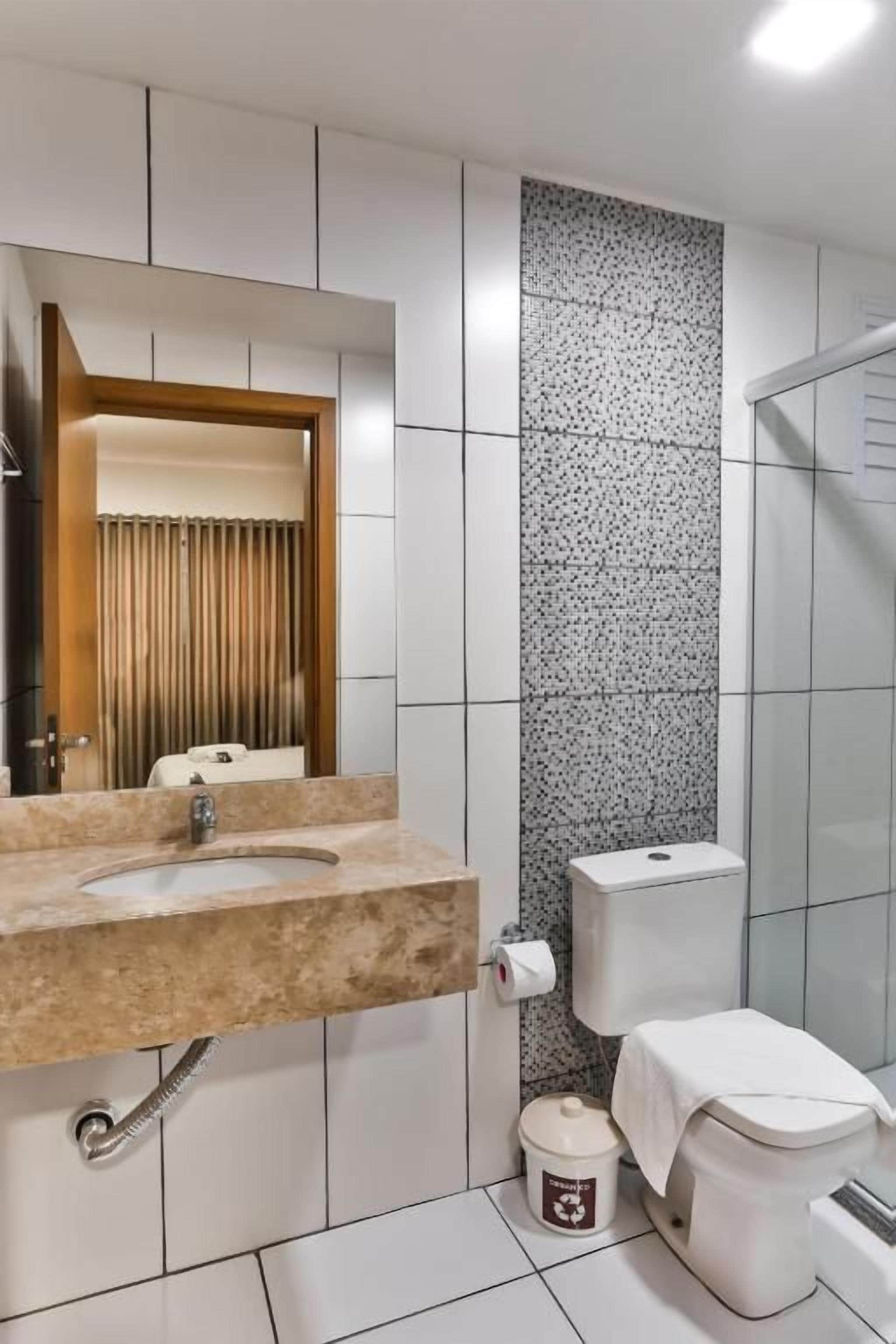 Un baño con lavamanos, inodoro y ducha.