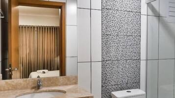 Un baño con lavamanos, inodoro y ducha.