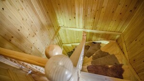Un interior de madera con una escalera de caracol y barandilla de madera.