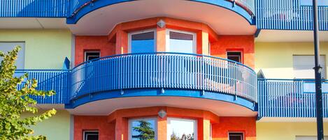 A multi-story hotel with balconies, a sign reading "Hotel CANTO," and a clear sky.