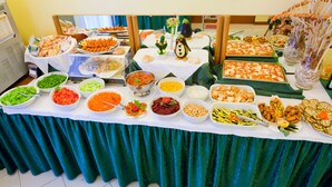 A buffet table with various food items and a decorative penguin figure. - Hotel Catto Suisse (Caorle)