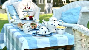 A picnic setup with a tiered cake, teapot, and coffee cups on a checkered tablecloth. - South Craighall Bed & Breakfast (Glasgow)