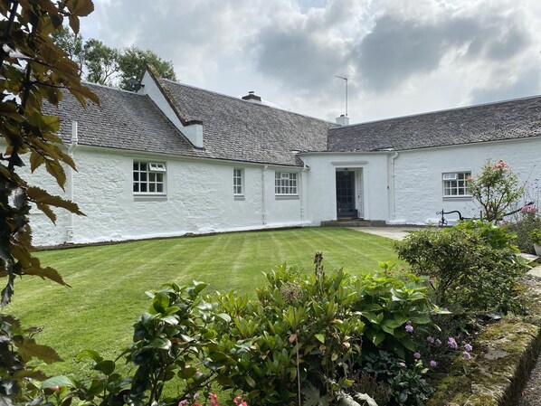 A white building with a sloped roof and a well-maintained lawn in front. - South Craighall Bed & Breakfast (Glasgow)