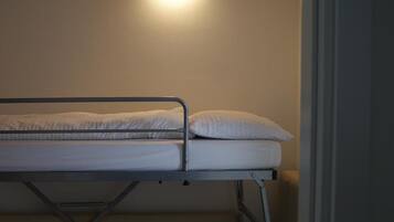 A bunk bed with a headboard and a light fixture above it.