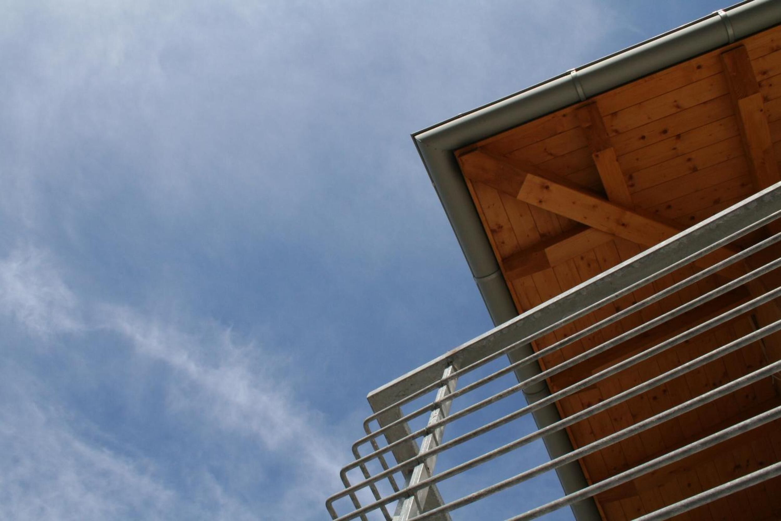 A modern building with a wooden interior and a metal railing.