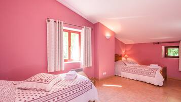 A pink-themed bedroom with two beds, a window with curtains, a wall-mounted lamp, and a tiled floor.