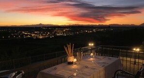 Ein Esstisch mit Blick auf eine Stadtlandschaft bei Sonnenuntergang.