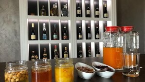A bar area with shelves of wine bottles and jars of pickled fruits and vegetables.