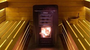 A sauna with a wooden interior and a visible fire.