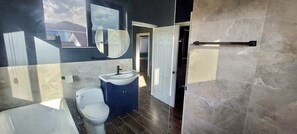 Uma casa de banho moderna com banheira, sanita e lavatório.