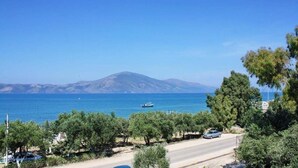 Une route côtière offrant une vue sur la mer et les montagnes lointaines.