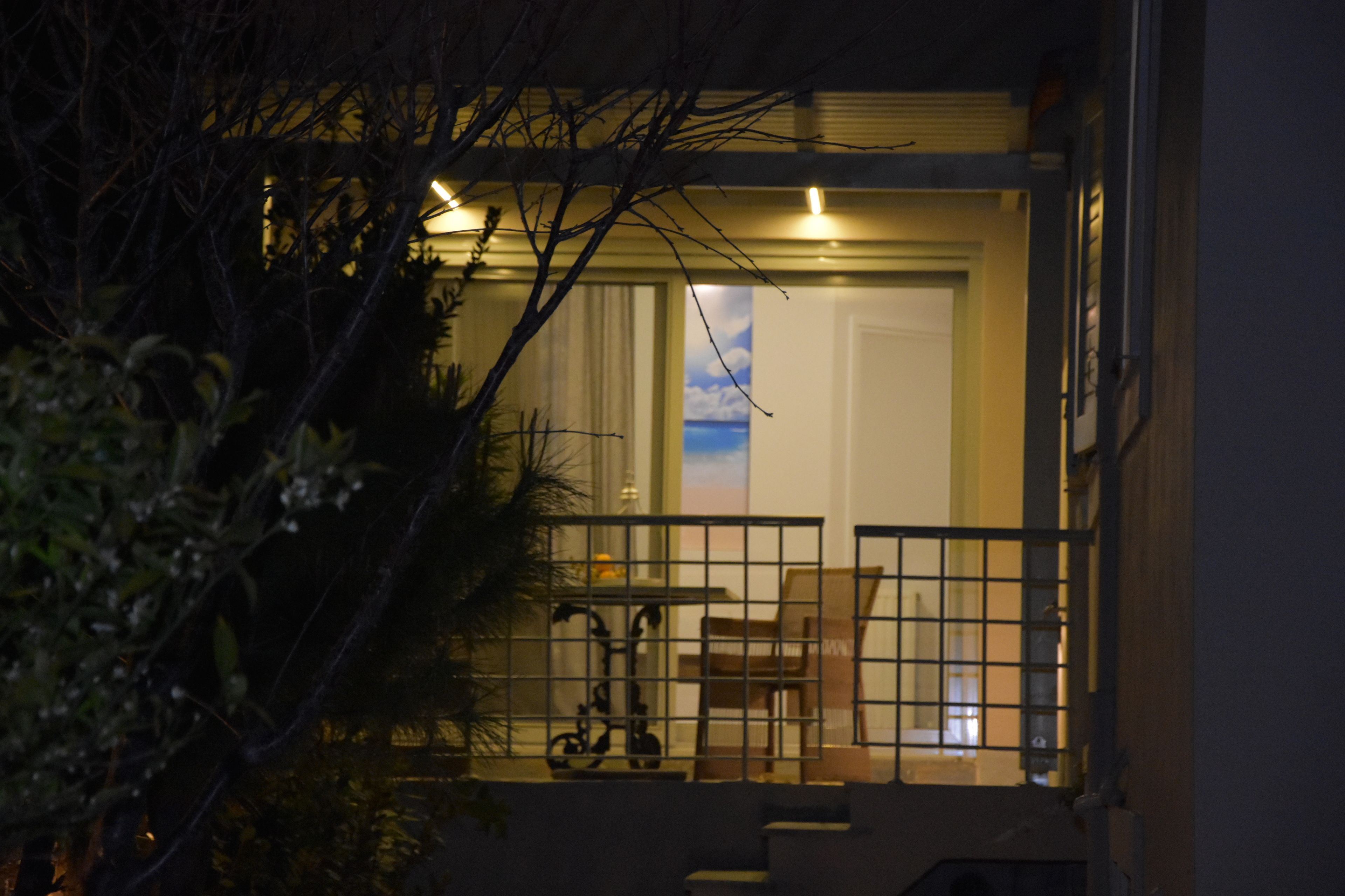 Une vue nocturne de l’entrée d’un immeuble, avec un escalier menant à une porte.