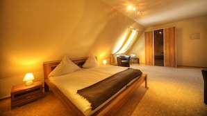 Um quarto com cama, mesas de cabeceira, uma cadeira e um guarda-roupa.