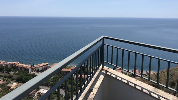 A balcony with a view of the sea and buildings. - La nave sul mare di Taormina B&B (Letojanni)