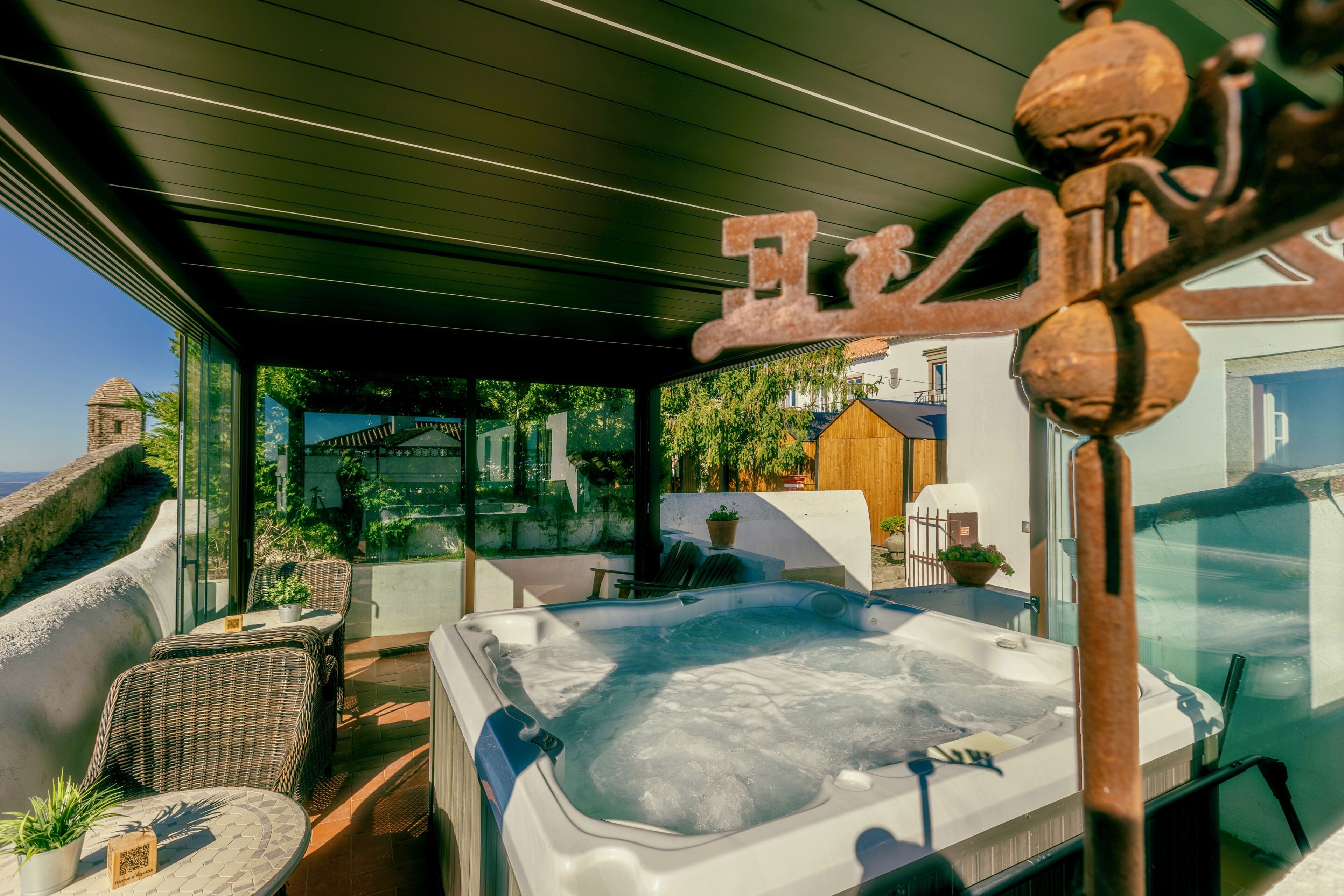 A hot tub with wicker furniture and a view of a coastal area.