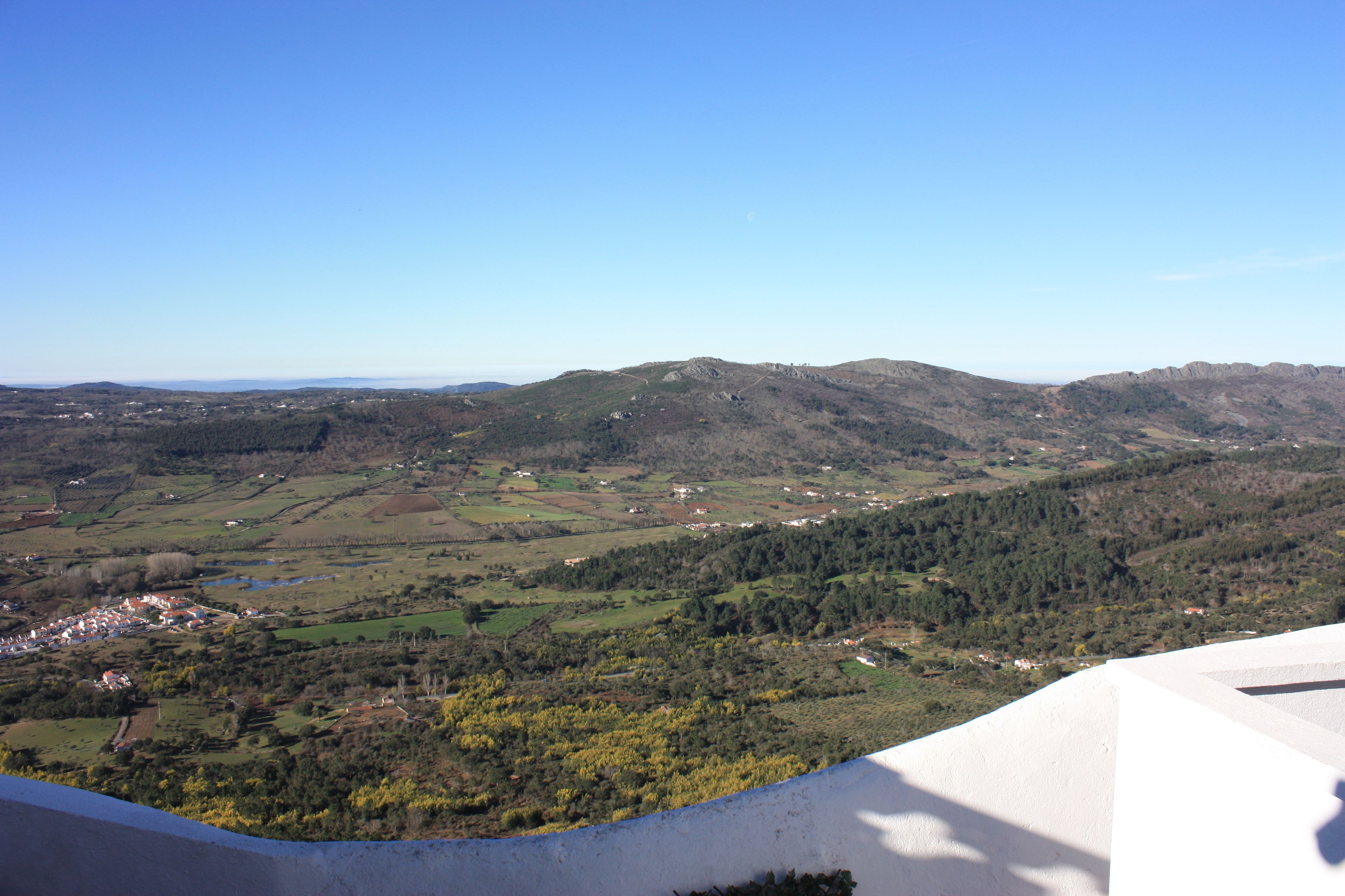 A panoramic view of a mountainous landscape with a small village nestled in the valley.
