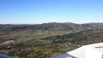 A panoramic view of a mountainous landscape with a small village nestled in the valley.