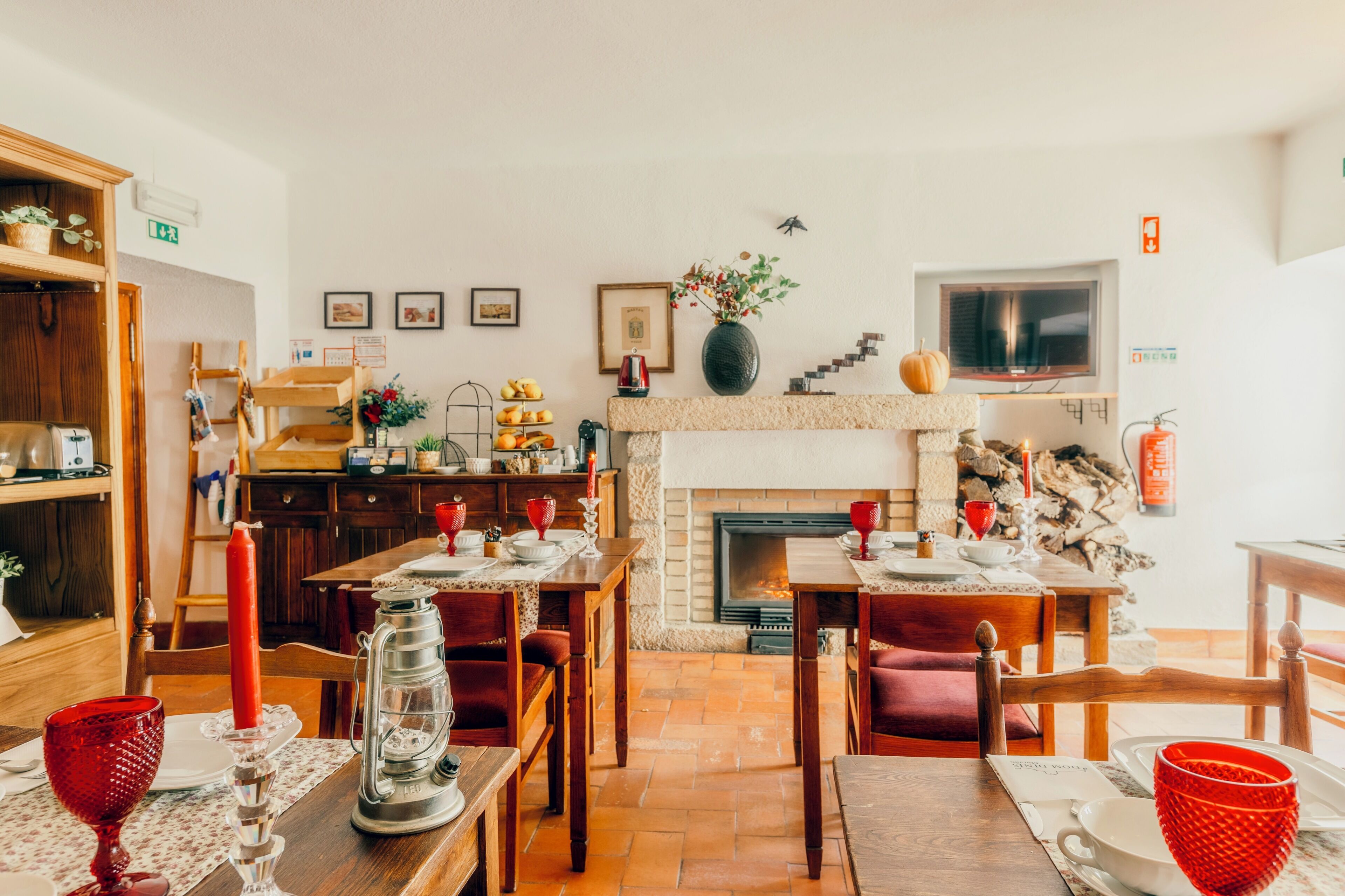 A cozy dining area with a fireplace, wooden furniture, and a variety of table settings.