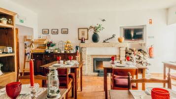 A cozy dining area with a fireplace, wooden furniture, and a variety of table settings.