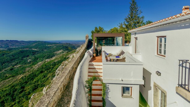 A white building with a terrace, a staircase, and a view of the landscape. - Dom Dinis Marvão (Marvao)