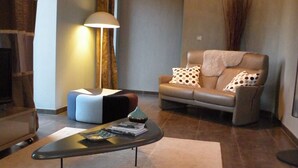 A modern living room with a sofa, a coffee table, and a lamp. - La Bergerie Baroque (Verrieres)