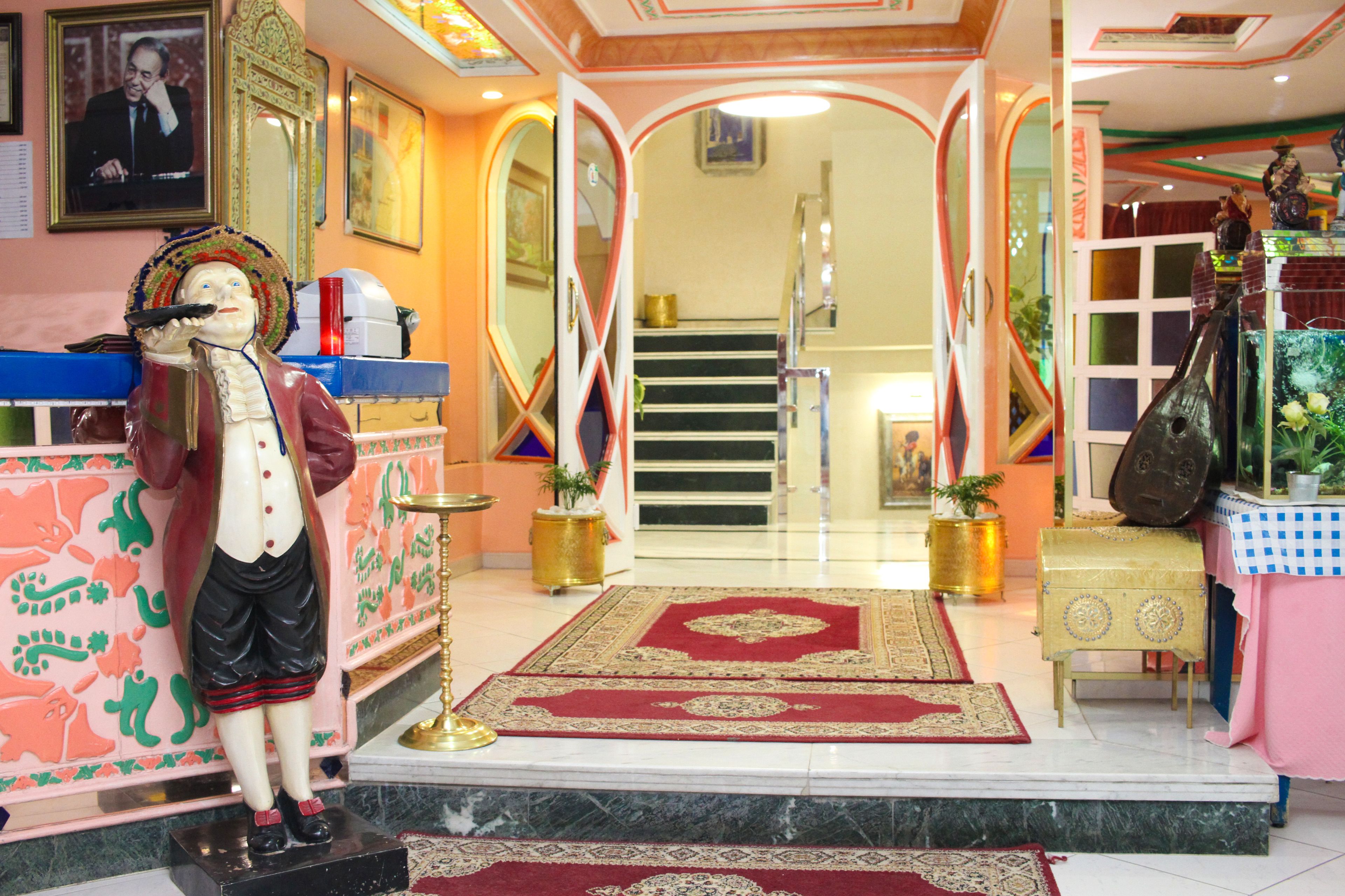 A hotel lobby with a statue, a staircase, and a patterned carpet.