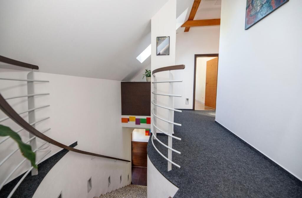 Uma escada moderna com corrimão de madeira e um hall com carpete.